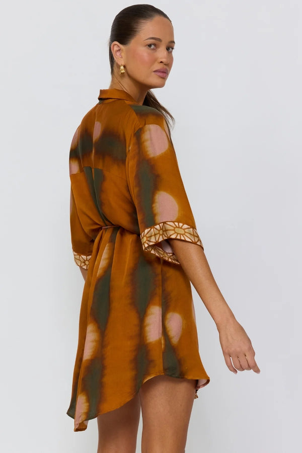 Woman wearing a patterned dress on a white background