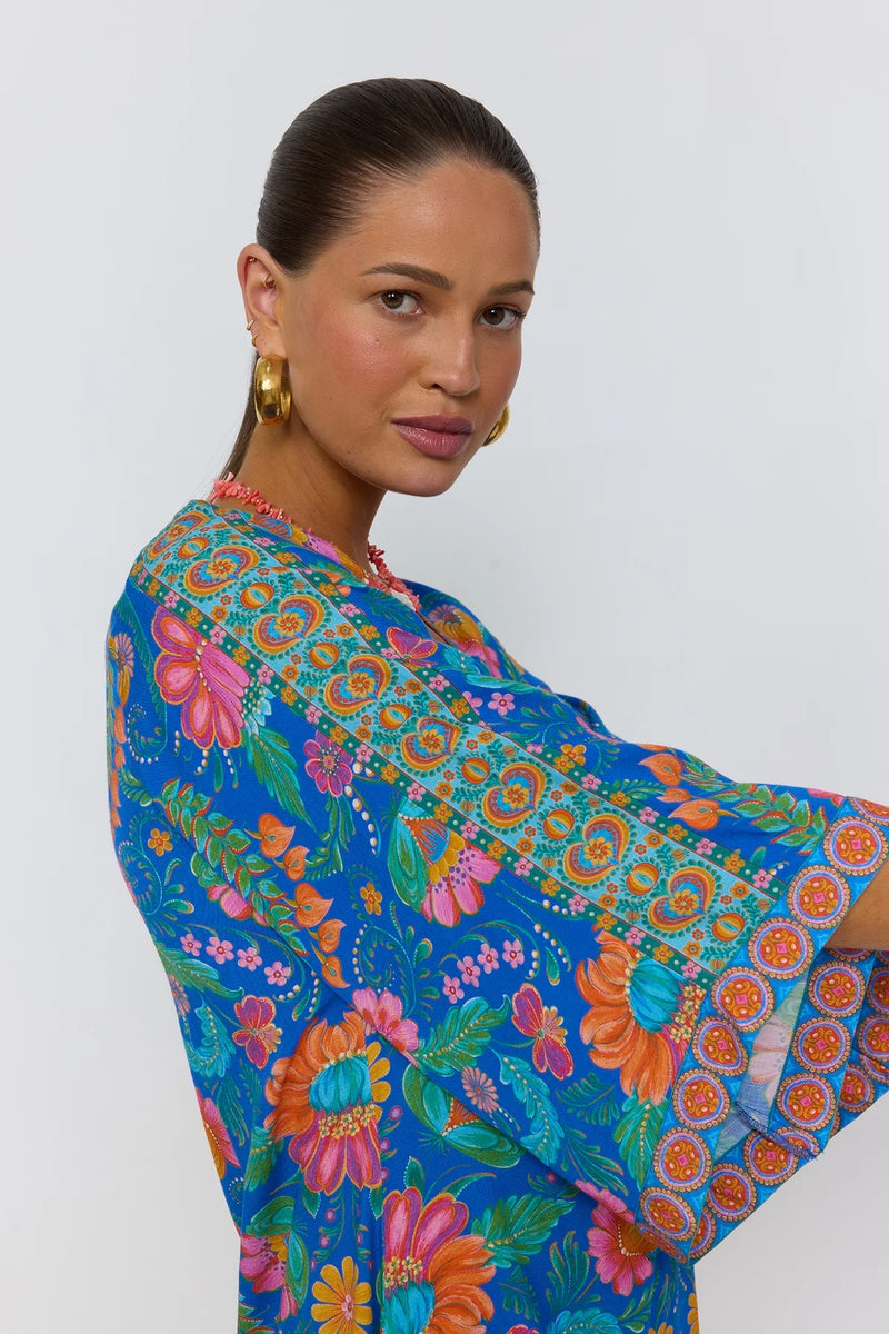 Woman wearing a colorful floral dress on a white background