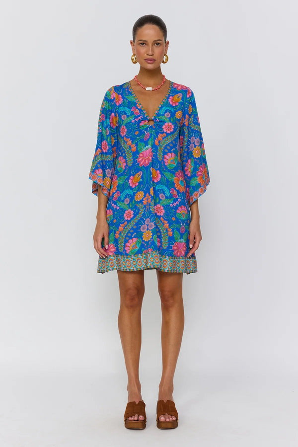 Woman wearing a colorful floral dress on a white background