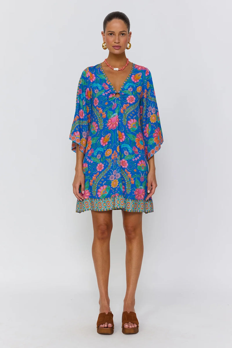 Woman wearing a colorful floral dress on a white background