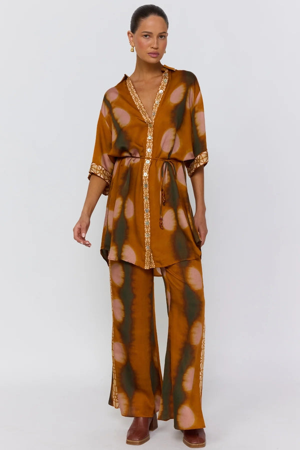 Woman wearing a patterned outfit on a white background