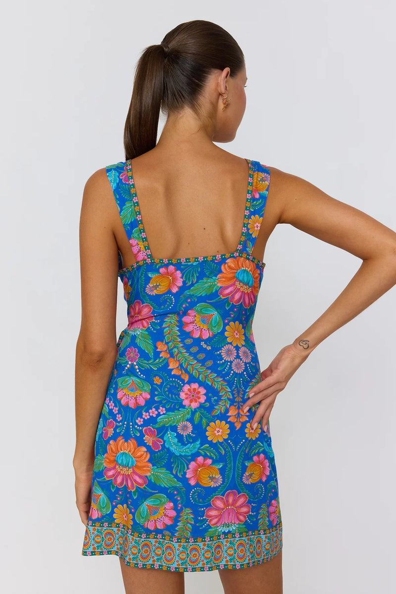 Woman wearing a colorful floral dress on a white background