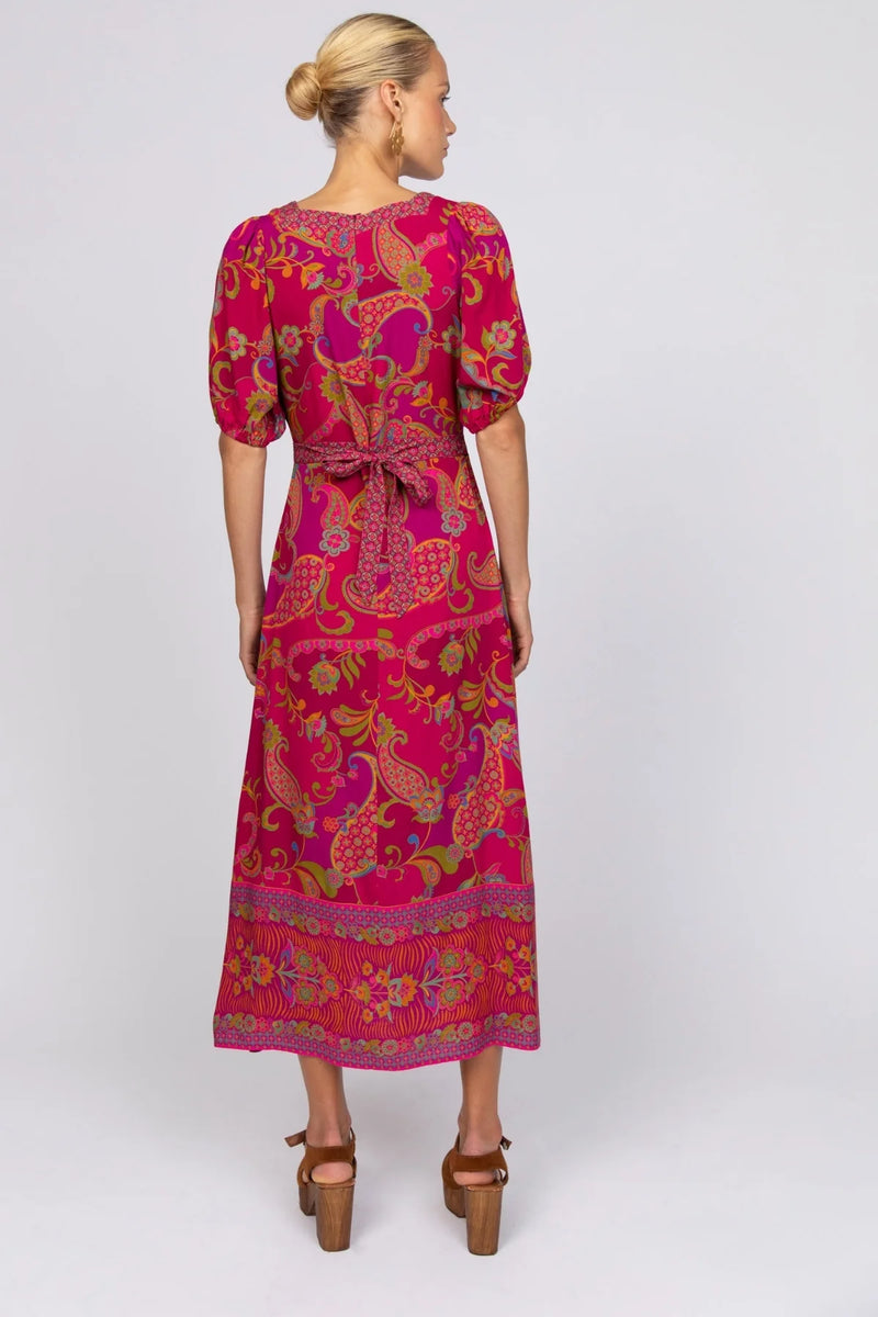 Woman wearing a pink patterned dress on a white background