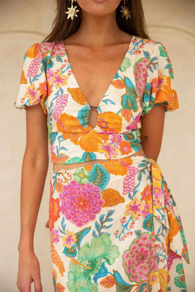 Woman wearing a colorful floral dress with a neutral background