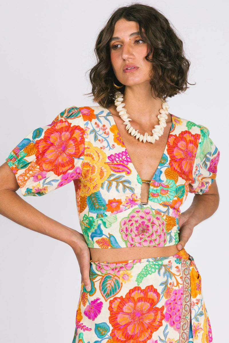 Woman wearing a colorful floral dress with a plain background
