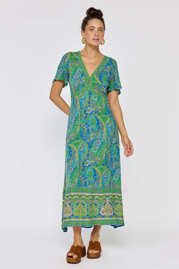 Woman wearing a green and blue patterned dress on a white background