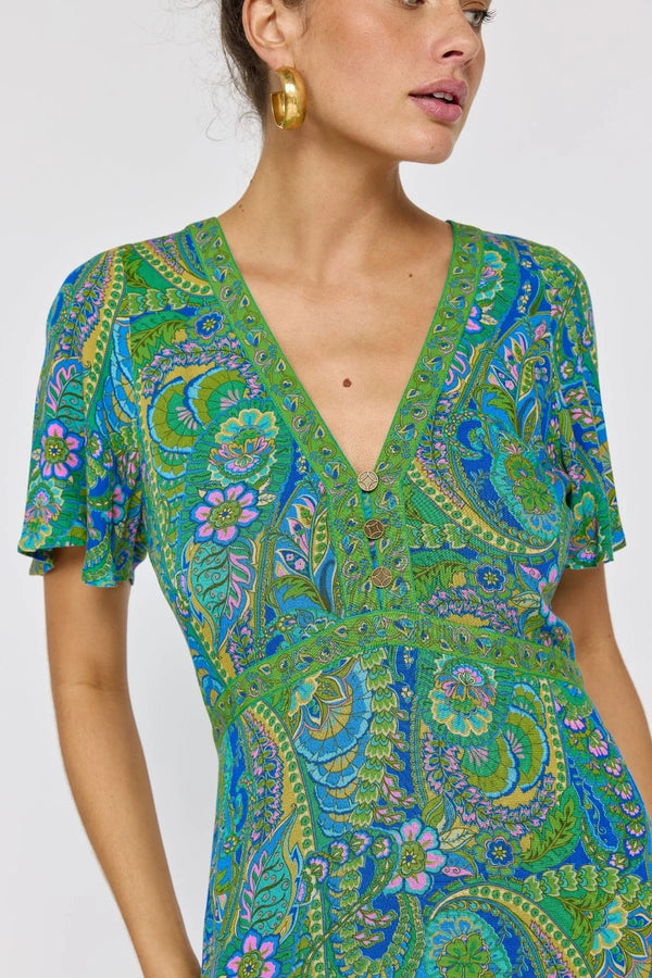 Woman wearing a green and blue patterned dress on a white background