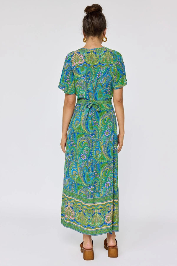 Woman wearing a green and blue patterned dress on a white background