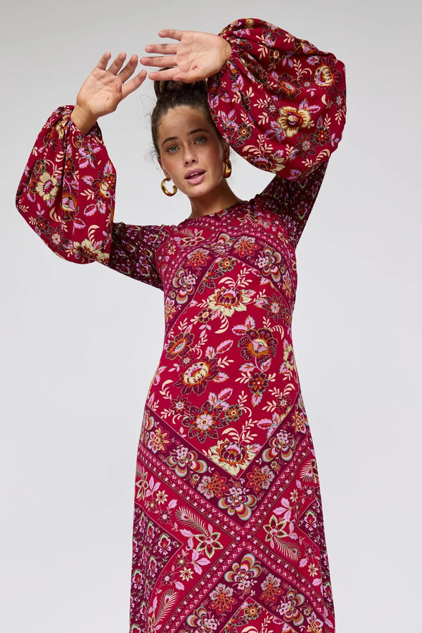 Woman wearing a red floral dress against a white background