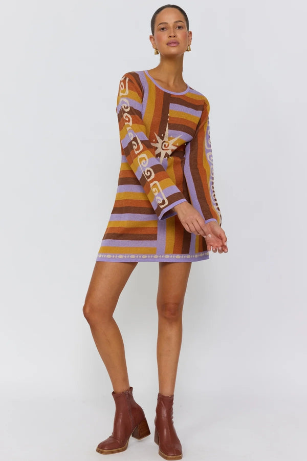 Woman wearing a patterned dress with long sleeves on a white background