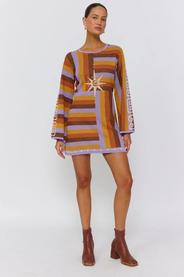 Woman wearing a patterned dress with long sleeves on a white background