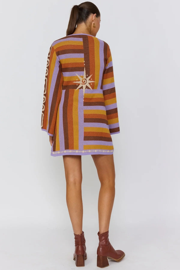 Woman wearing a colorful striped dress with a white background