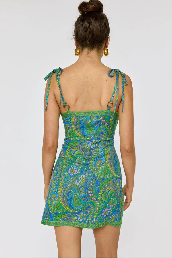 Woman wearing a green and blue patterned dress on a white background