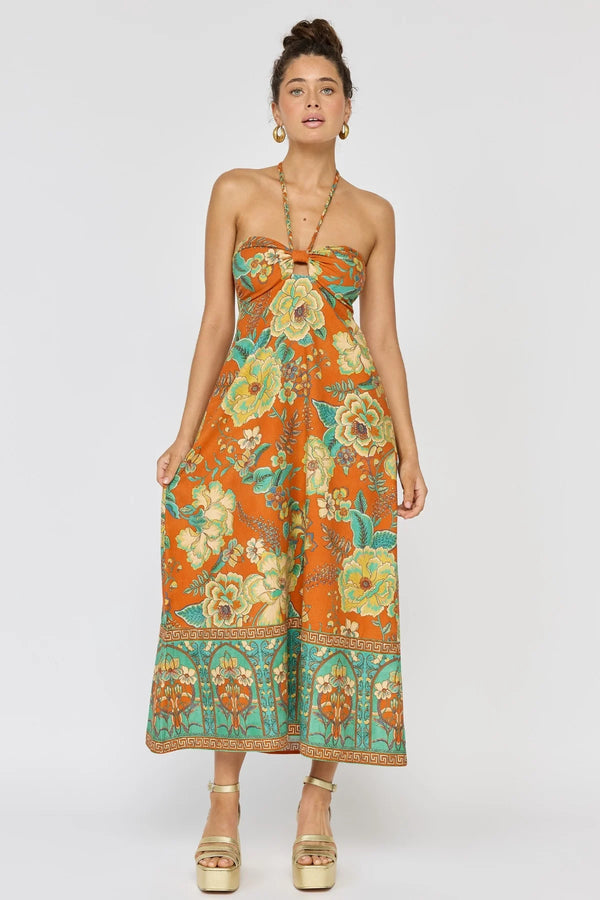 Woman wearing a strapless floral dress with an orange and green pattern on a white background