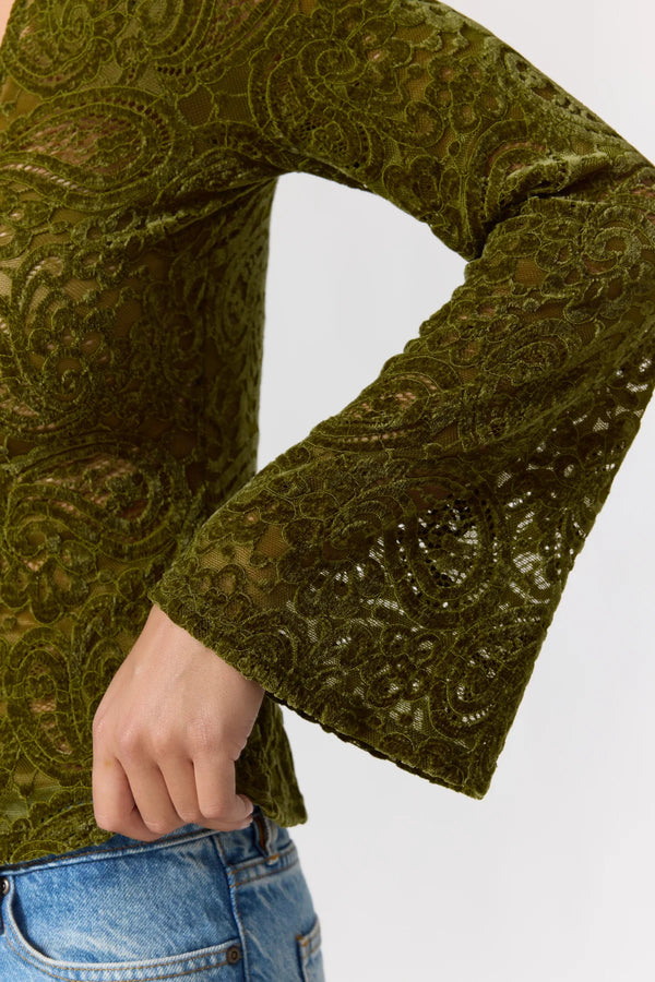Green patterned long-sleeve top with a white background