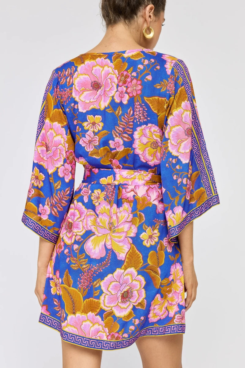 Woman wearing a colorful floral dress with a blue background