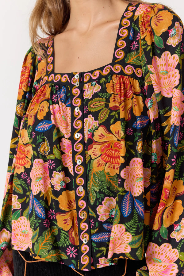 Colorful floral patterned top with a brand logo on a white background