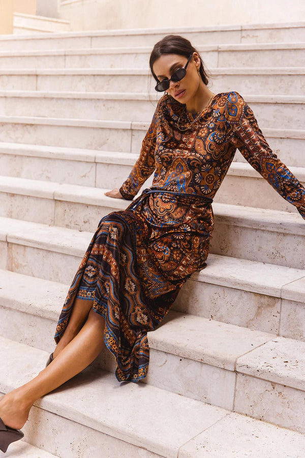 Woman in a patterned dress sitting on stone steps