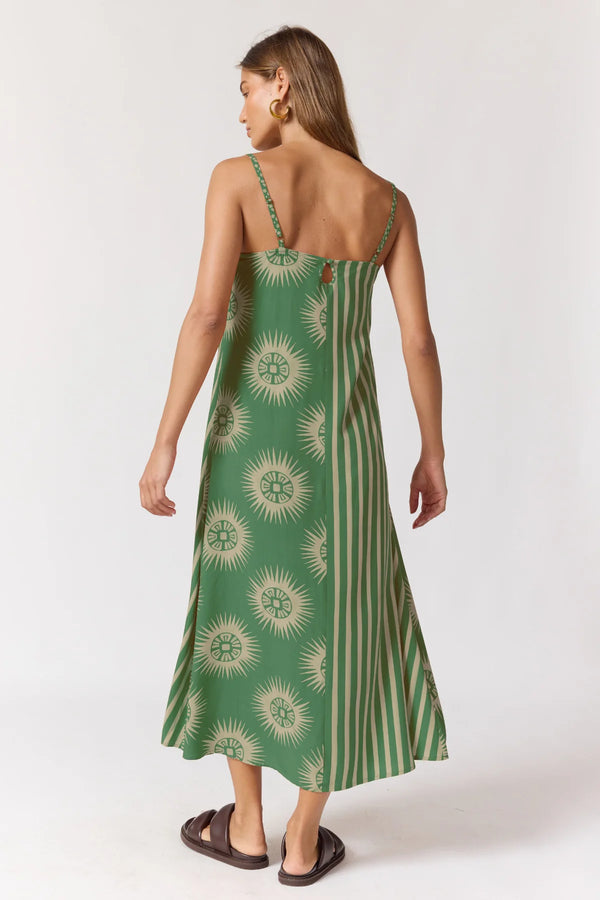 Woman wearing a green dress with sunflower pattern on a white background