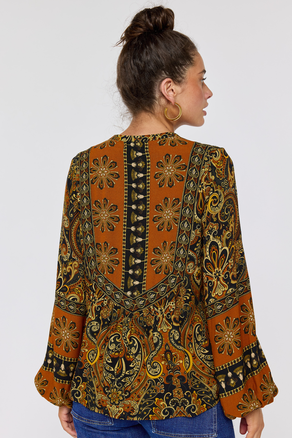 Woman wearing a patterned blouse with a plain background