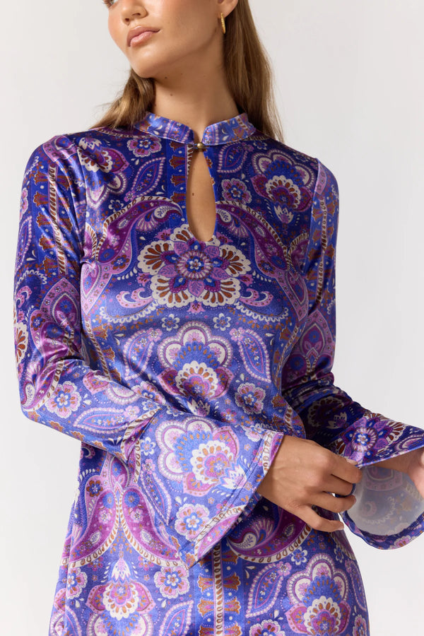 Woman wearing a purple patterned dress on a white background