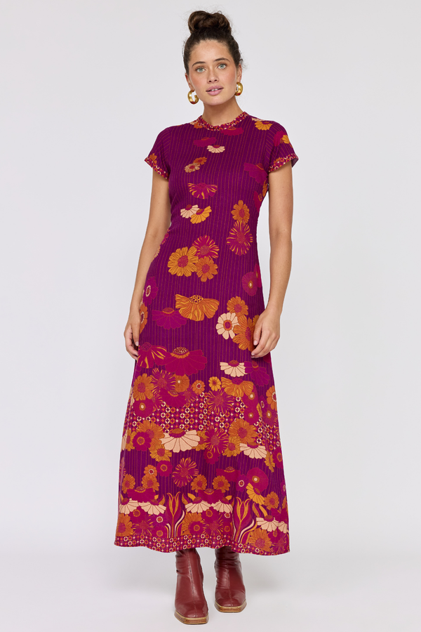 Woman wearing a purple dress with floral pattern on a white background