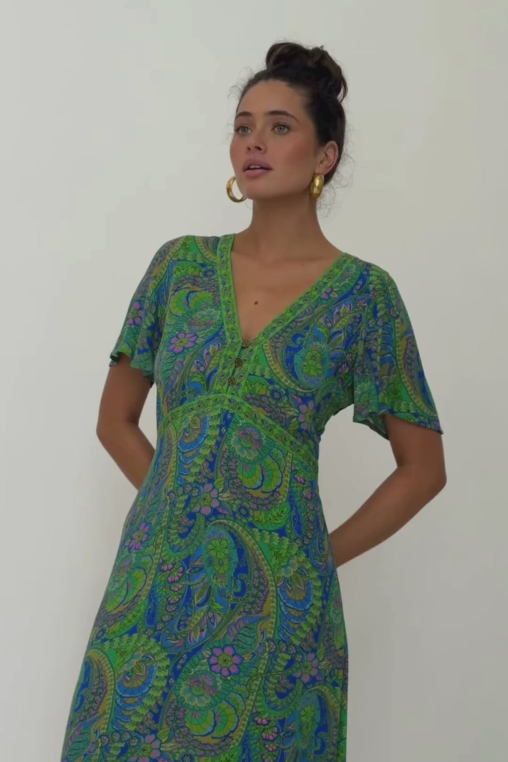 video of woman in blue and green dress swishing back and forth